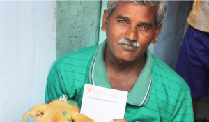 A man holds a rabies certificate to prove his dog is vaccinated.